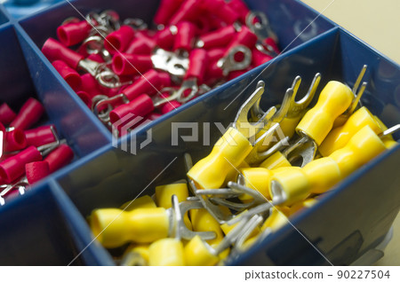 A set of colored crimp terminals for electrical wires. Crimping sleeves of different sizes. Plastic spare parts box for electrician. Toolbox. Selective focus A set of colored crimp terminals for electrical wires. Crimping sleeves of different sizes. Plastic spare parts box for electrician. Toolbox. Selective focus 90227504