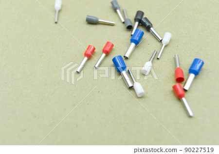 Coloured crimp terminals for different wire sizes. Copper sleeves for crimping electrical cables. Ferrules. Selective focus, copy space 90227519