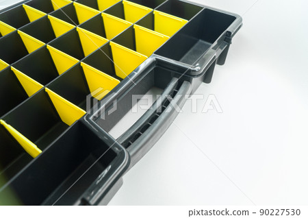 Empty box with cells for storing small parts and fasteners. Sectional tool box. Organizer. Selective focus Empty box with cells for storing small parts and fasteners. Sectional tool box. Organizer. Selective focus 90227530