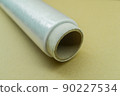 Roll of food stretch film for food packaging. Packaging film in a roll on a cardboard spool. Selective focus 90227534
