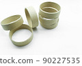 Narrow cardboard spools for winding rolled materials and self-adhesive labels. Reels made of cardboard for printing houses. Selective focus, isolated on white 90227535