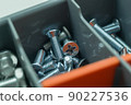 New metal screws for connecting parts. Fasteners in a tool box. Little cogs. Selective focus 90227536