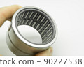 Needle bearing in hand. Roller bearing for motors, machinery and equipment. Spare part. Selective focus, isolated on white 90227538