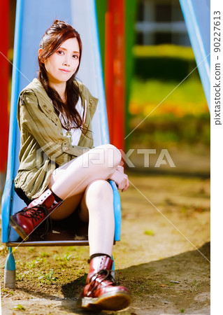 A cute female portrait on a slide in an abandoned elementary school 90227613