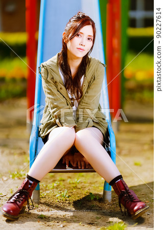 A cute female portrait on a slide in an abandoned elementary school 90227614