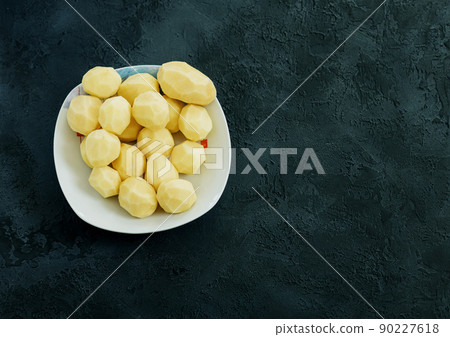Raw potato on dark background Raw potato on dark background 90227618