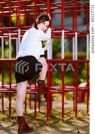 A cute female portrait at a closed elementary school jungle gym 90227713