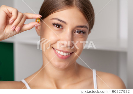 Beautiful Woman Holding Fish Oil Pill In Hand 90227922