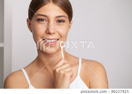Smiling women use dental floss white healthy teeth. 90227925