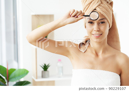 Woman holding magnifier and zoom damage on skin 90229107