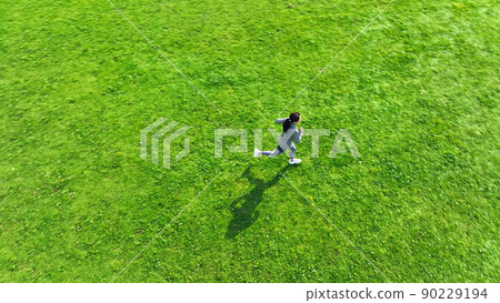 Aerial view of a woman running in the meadow 90229194