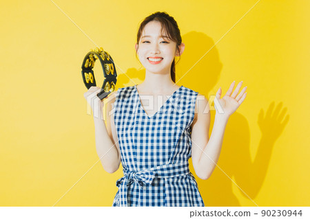 Summer woman yellow background tambourine 90230944