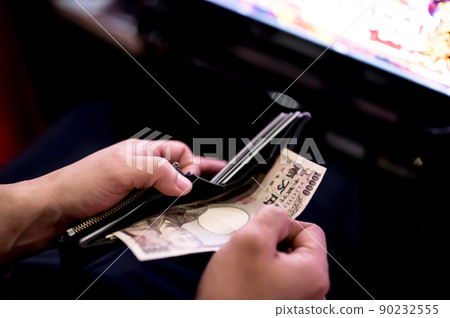 Investing a 10,000 yen bill from a wallet at a pachinko parlor 90232555
