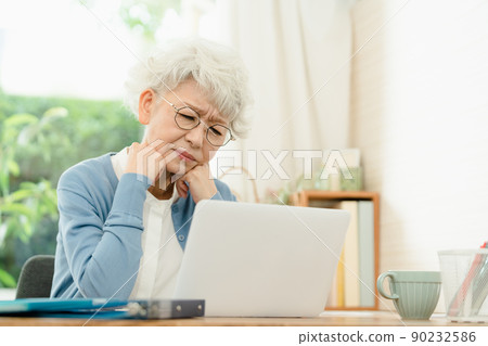 Senior woman in poor physical condition heading to a computer 90232586
