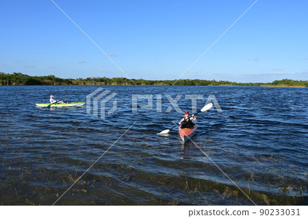 Woman and active senior kayaking on Nine Mile Pond in Everglades National Park. 90233031