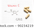 Chemical formula of Vitamin C and some pills on the white paper background. Close-up. Vitamins for health. 90234219