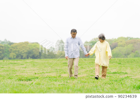 Senior couple walk outdoors 90234639