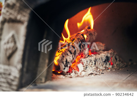 Wood-fired pizza oven with birch logs for kindling. The fire burns and the oven heats up. Front view. Wood-fired pizza oven with birch logs for kindling. The fire burns and the oven heats up. Front view. 90234642
