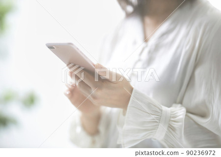 Hands of a middle-aged woman who operates a smartphone 90236972
