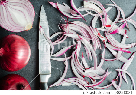 Red onion and sliced onion on a wooden chopping Board. Side view. Red onion and sliced onion on a wooden chopping Board. Side view. 90238081
