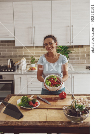 Beautiful woman is cooking delicious dishes at her home kitchen Beautiful woman is cooking delicious dishes at her home kitchen 90238191