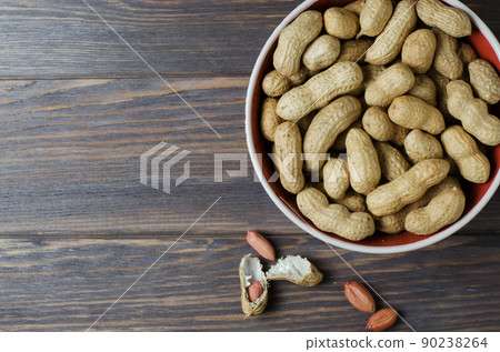Peanuts nuts on the plate. Dark wooden background. Copy space 90238264
