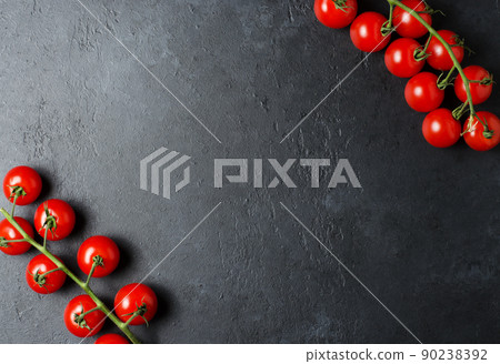 Ripe red tomatoes on a green branch. Vitamin-rich vegetables. Dark background. Flat lay. Copy space Ripe red tomatoes on a green branch. Vitamin-rich vegetables. Dark background. Flat lay. Copy space 90238392