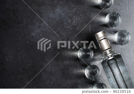 Bottle of vodka. Vodka in glass glasses. Dark black background. Copy space 90238516