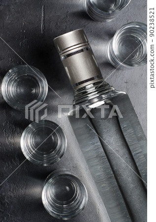 Bottle of vodka. Vodka in glass glasses. Dark black background. Vertical photo 90238521