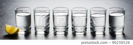 Vodka in glass glasses. Piece of lemon. Horizontal photo 90238526