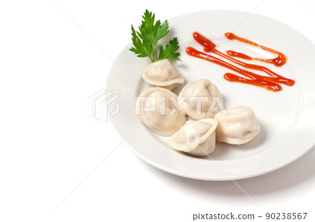 Traditional Russian pelmeni, ravioli, dumplings on a white plate with red sauce and parsley. White background. 90238567