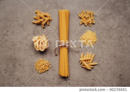 Flat Lay of Different Types of Pasta Laid Up Around Handful of Spaghetti on the Table Flat Lay of Different Types of Pasta Laid Up Around Handful of Spaghetti on the Table 90239881