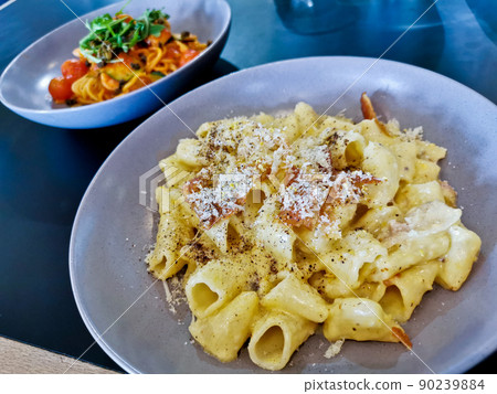 Penne pasta carbonara on white sauce with bacon and extra topping cheese served on blue plate Penne pasta carbonara on white sauce with bacon and extra topping cheese served on blue plate 90239884