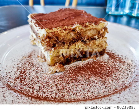Homemade fluffy soft sweet Tiramisu Italian dessert served on white dish Homemade fluffy soft sweet Tiramisu Italian dessert served on white dish 90239885