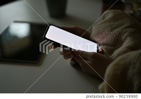 Close-up image, A female hands holding a smartphone white screen mockup Close-up image, A female hands holding a smartphone white screen mockup 90239980