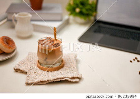 Closeup, Office workspace with a glass of iced latte, laptop computer and accessories Closeup, Office workspace with a glass of iced latte, laptop computer and accessories 90239984