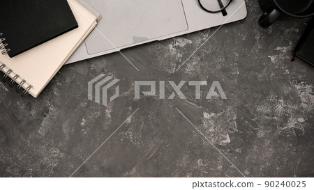 Modern workspace with laptop, spiral notebook and copy space on loft grey background. 90240025