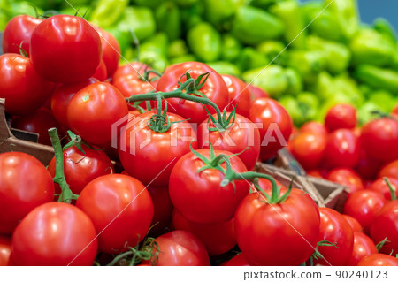 Close-up shot of fresh ripe tomatoes and sweet peppers in modern supermarket, copy space 90240123