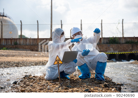 Ecologist sampling taken dead fish to inspaction and save data to laptop computer 90240690