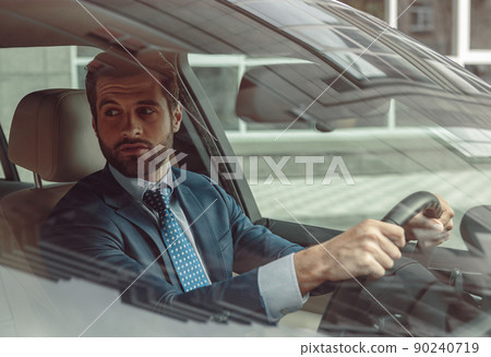 Confident businessman in suit having business journey by automobile 90240719
