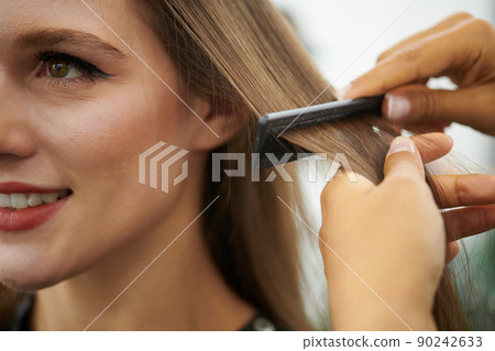 Hairstylist Brushing Hair of Client Hairstylist Brushing Hair of Client 90242633