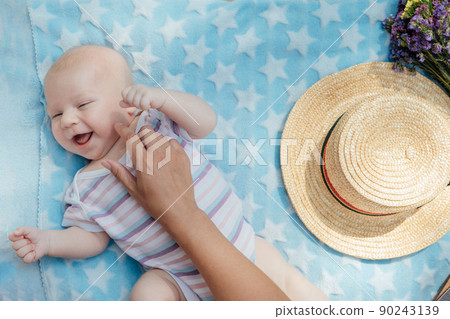 Newborn baby spending time outside. Happy and smiling mother with her newborn baby spending time in the park. Getting fresh air and natural sunlight for babies. 90243139