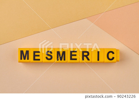 Word mesmeric written on plastic blocks on color background. 90243226