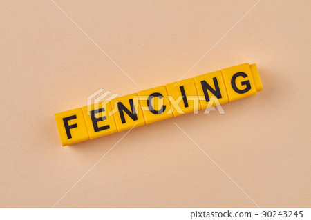 Black word fencing written on yellow cubes close up. Black word fencing written on yellow cubes close up. 90243245