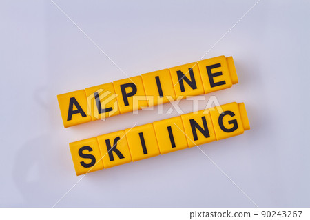 The inscription alpine skiing written on yellow cubes against white background. The inscription alpine skiing written on yellow cubes against white background. 90243267