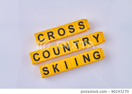 The inscription cross country skiing written on yellow cubes against white background. 90243270