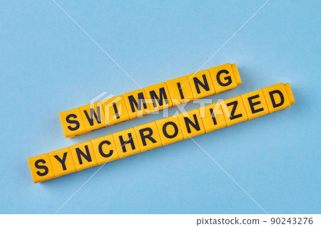 The inscription swimming synchronized written on yellow cubes against blue background. The inscription swimming synchronized written on yellow cubes against blue background. 90243276