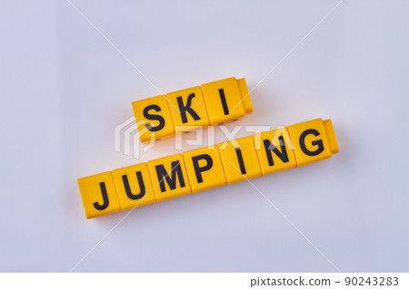 The inscription ski jumping written on yellow cubes against light background. The inscription ski jumping written on yellow cubes against light background. 90243283
