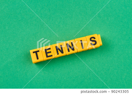 Word tennis written on yellow cubes against green background. 90243305