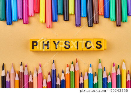Word physics written on yellow cubes in frame from colorful school supplies. Word physics written on yellow cubes in frame from colorful school supplies. 90243366